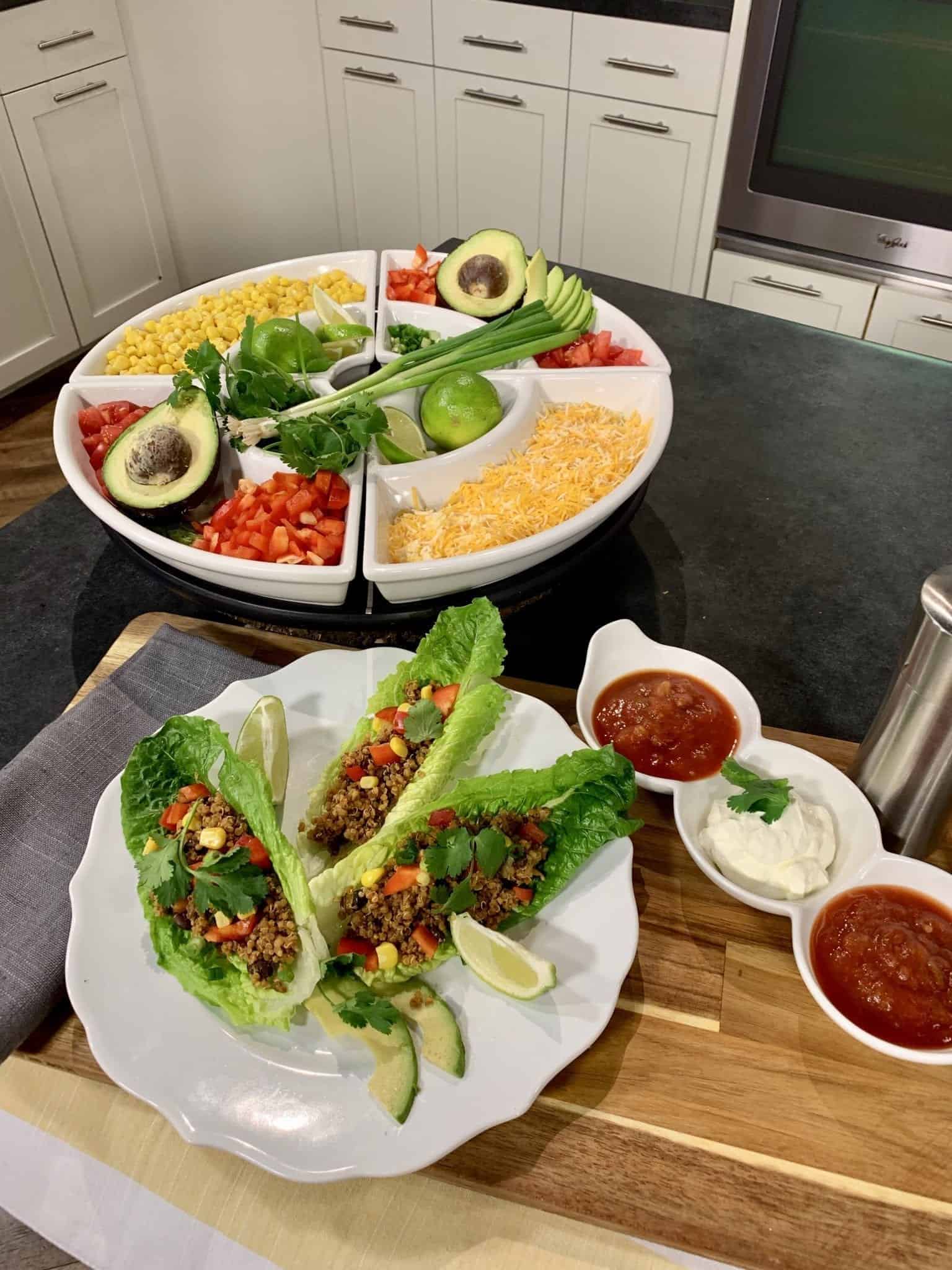 Instant Pot Lettuce Wraps with quinoa beef and bean mixture, avocado, and lime with a platter of taco toppings. Cheese, peppers, lime, green onions, corn, salsa, sour cream