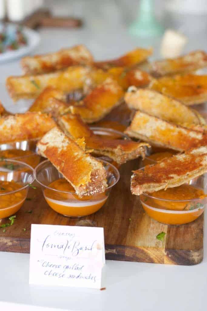 Mini cups of tomato basil soup with grilled cheese sandwiches on top. Perfect baby shower food!