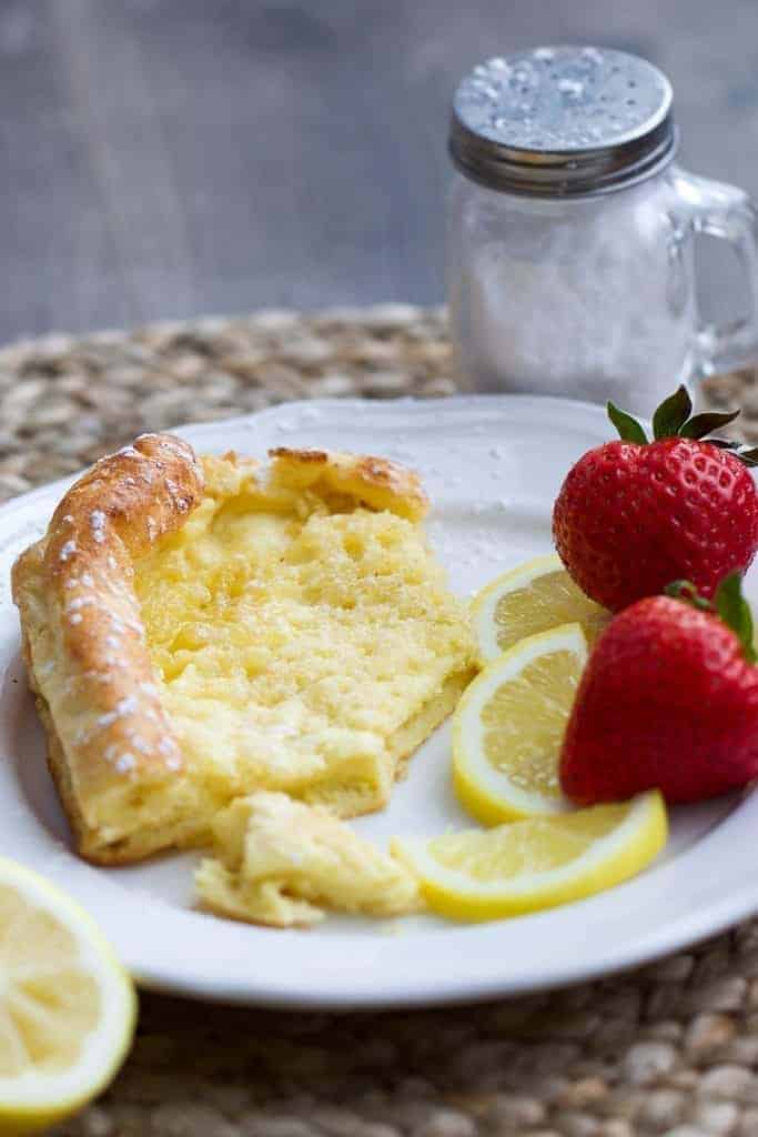 one slice of german pancake or dutch baby pancake with lemon and strawberries