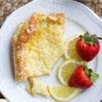 one slice of german pancake or dutch baby pancake with lemon and strawberries