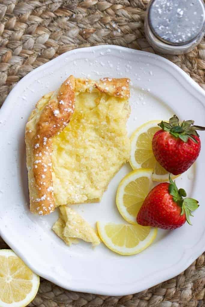 one slice of german pancake or dutch baby pancake with lemon and strawberries