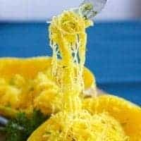 Spaghetti Squash on a fork with parsley and pepper cooked in the instant pot pressure cooker. a strand of spaghetti squash