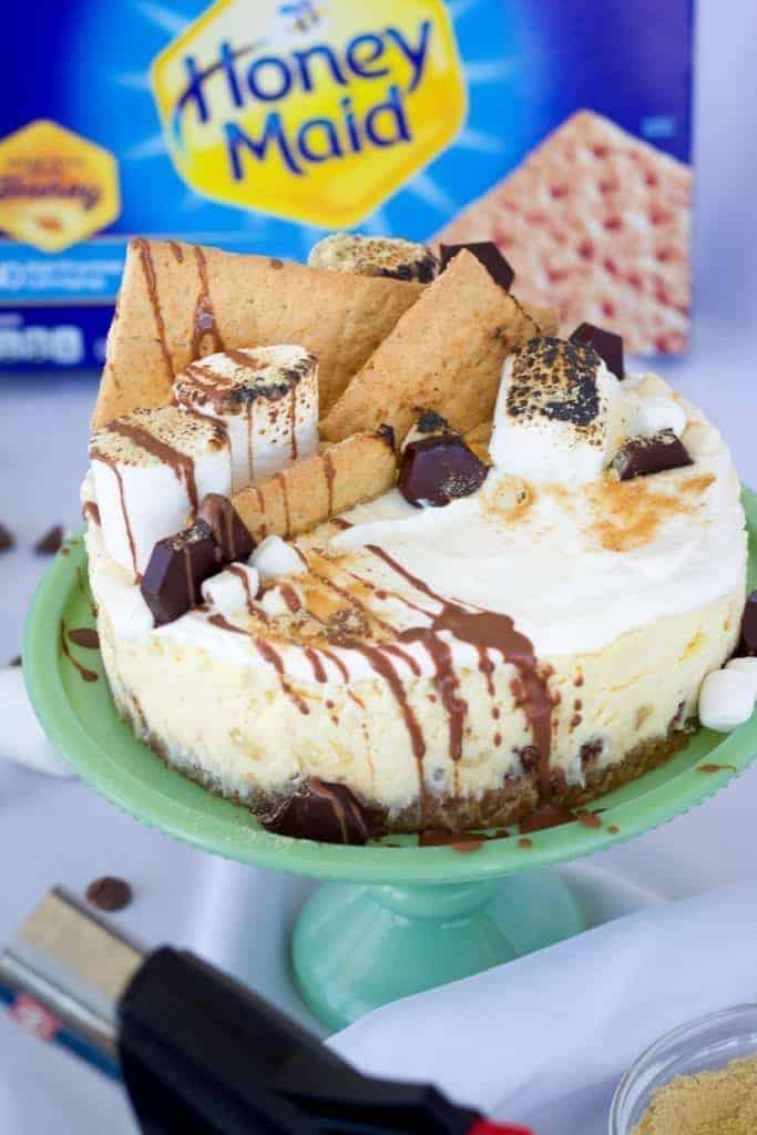 Instant Pot Smores Cheesecake with a kitchen torch and honey maid graham crackers in the background