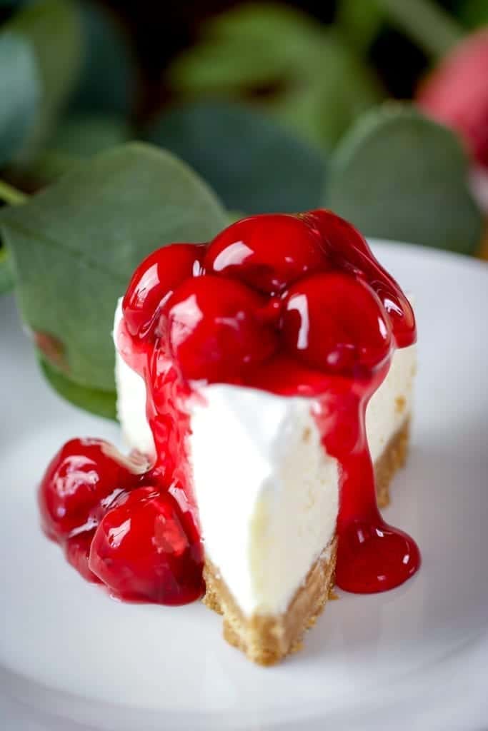 a piece of instant pot cheesecake with cherry topping