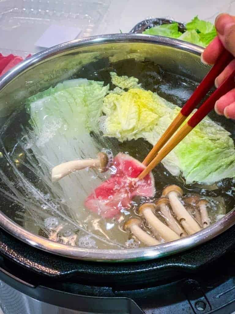 beef being dipped into the Instant Pot for homemade shabu shabu