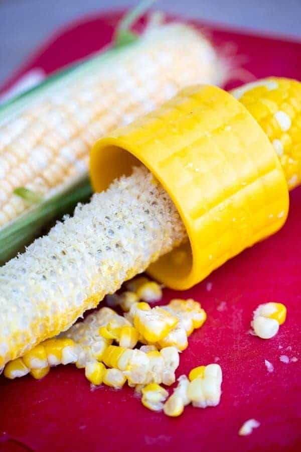 corn on the cob stripper on a red cutting board