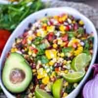 bowl of salsa with an avocado and lime