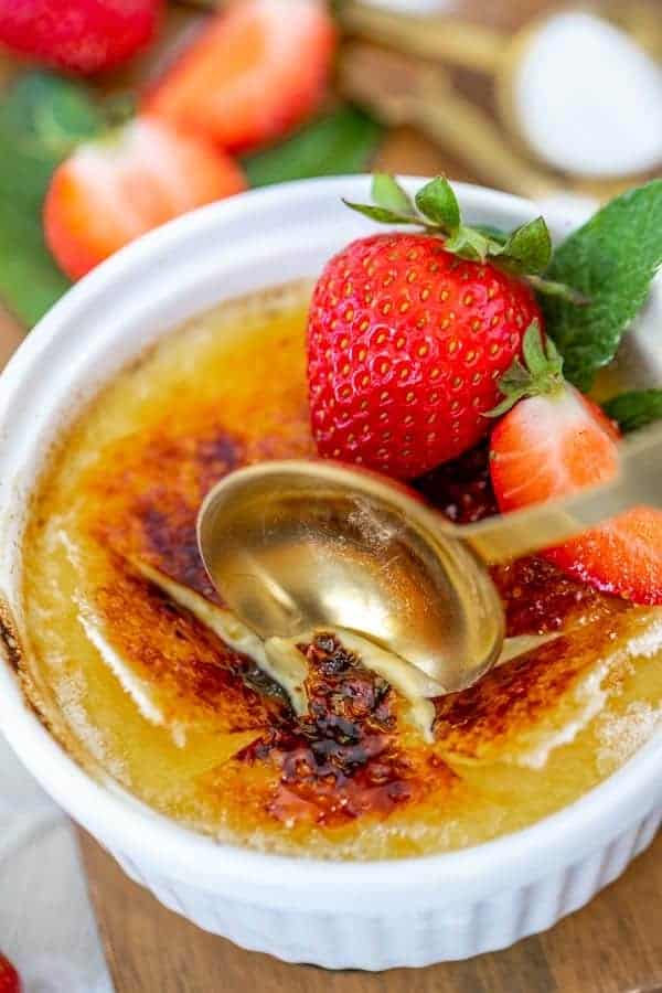 cracking into the creme brulee with a gold spoon