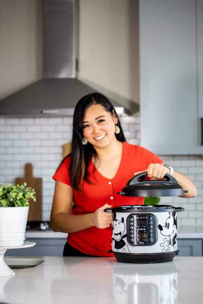 Lisa childs holding an instant pot lid with a mickey instant pot