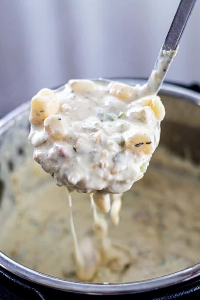 A spoonful of clam chowder with the Instant Pot in the background