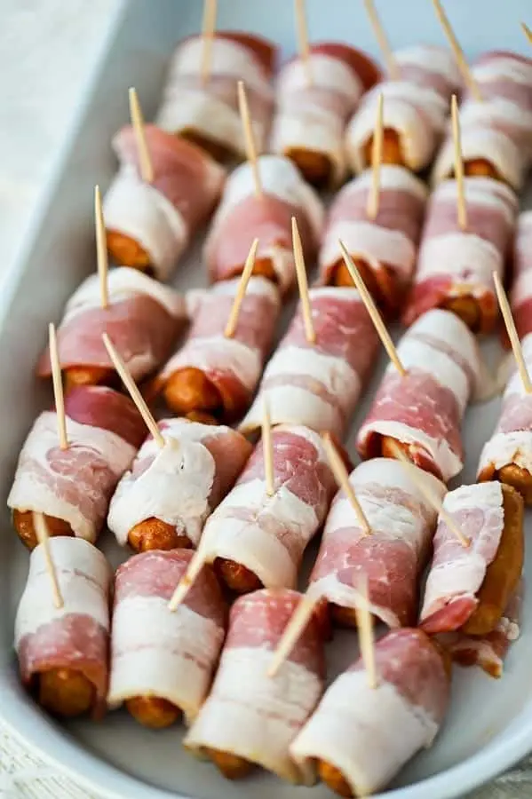 rows of uncooked little smokies wrapped in bacon