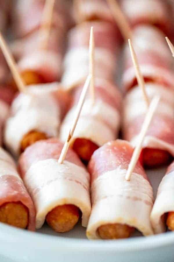 rows of uncooked bacon wrapped smokies