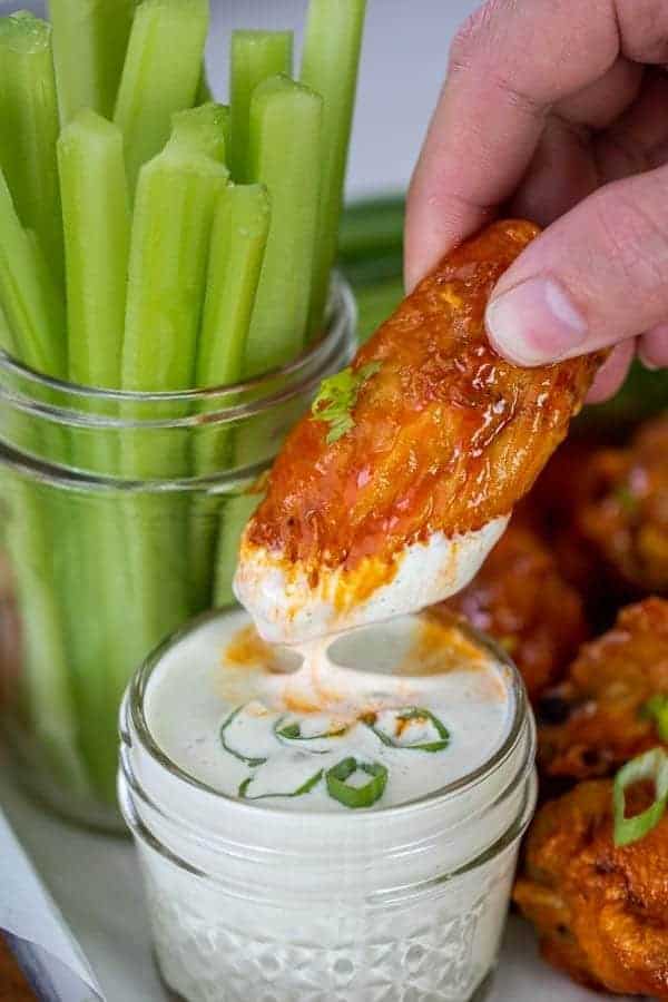 a chicken wings cooked from frozen in the air fryer dipping into ranch