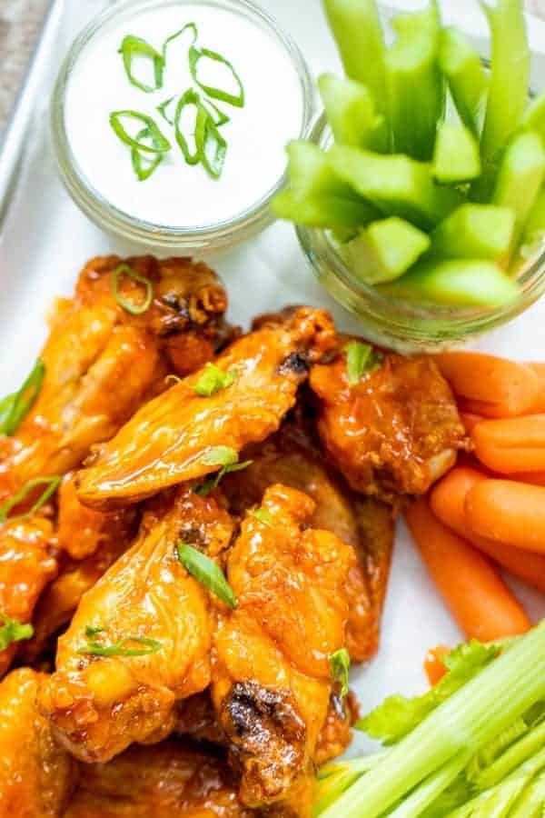 a plate of chicken wings with vegetables and ranch