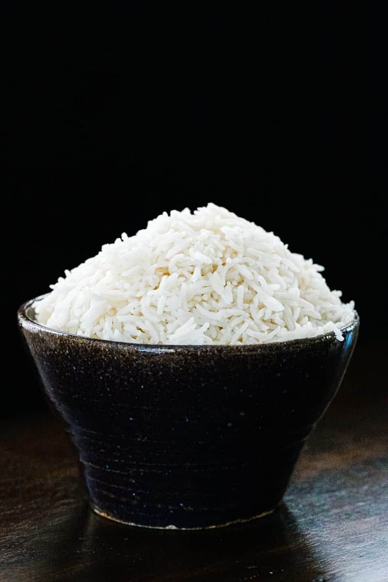 a bowl of basmati rice on a black backdrop