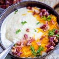 a bowl of cauliflower soup with bacon and cheese