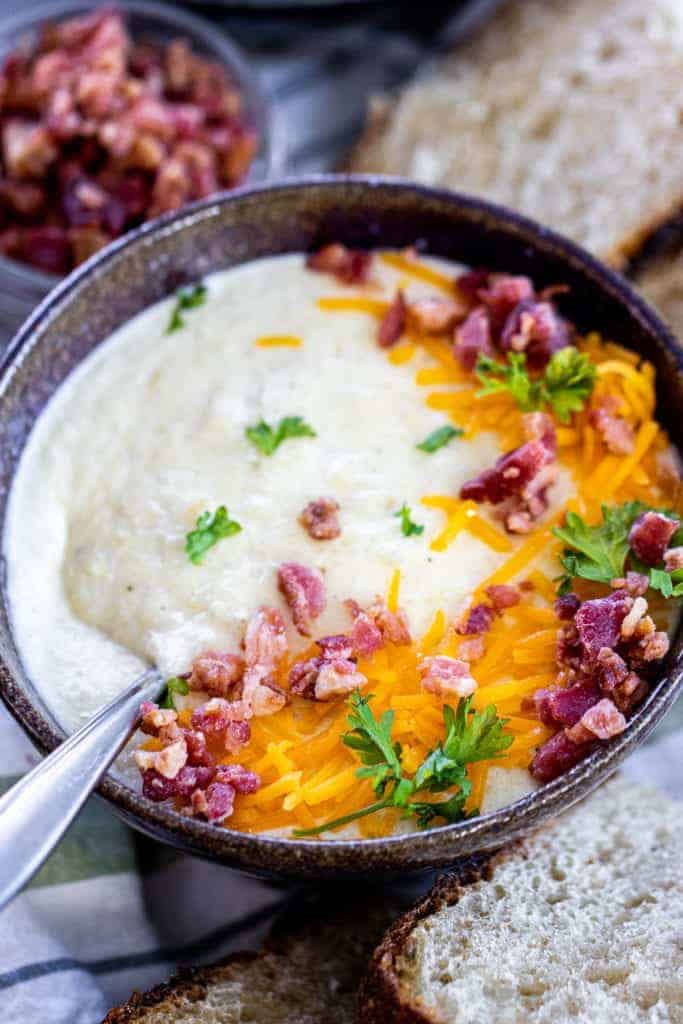 a bowl of cauliflower soup with bacon and cheese