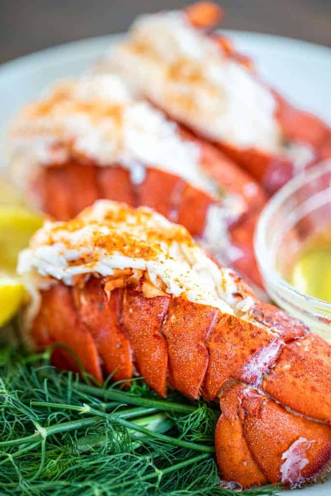 a couple lobster tails on a bed of dill