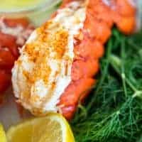 a single lobster tail with lemon, dill, and old bay seasoning