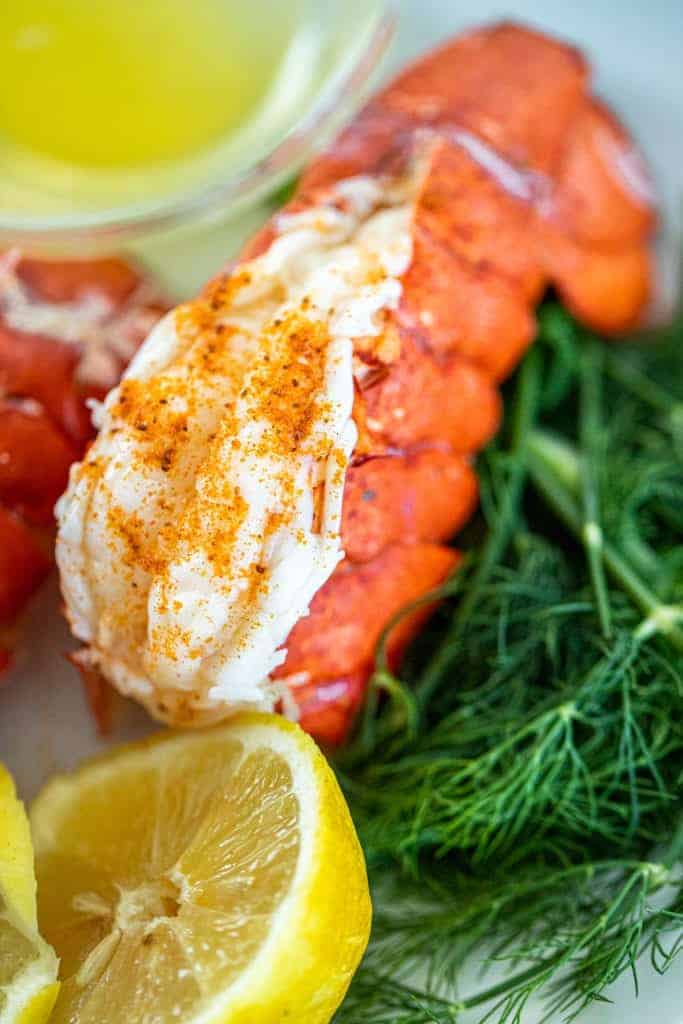 a single lobster tail with lemon, dill, and old bay seasoning