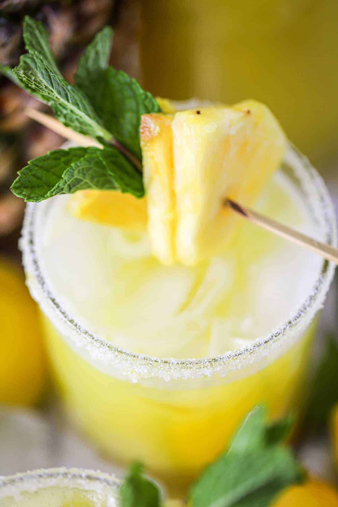 a glass of pineapple gingner lemonade with mint