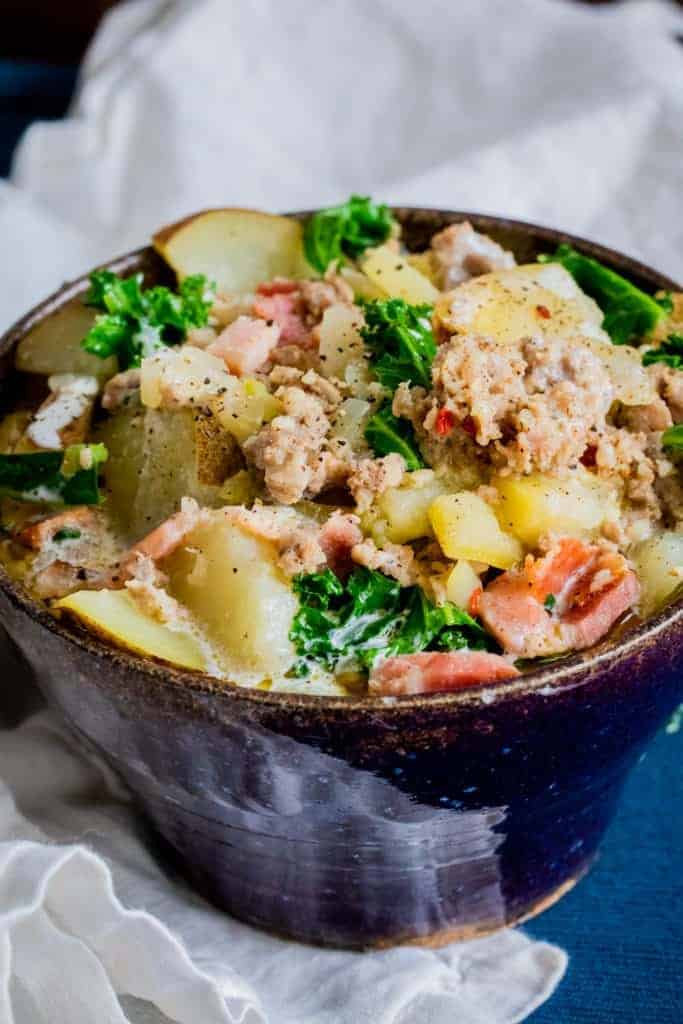 a bowl of zuppa toscana in a blue bowl