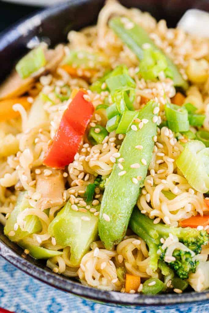 Close up of ramen stir fry with broccoli, sugar snap peas, green onions, and sesame seeds