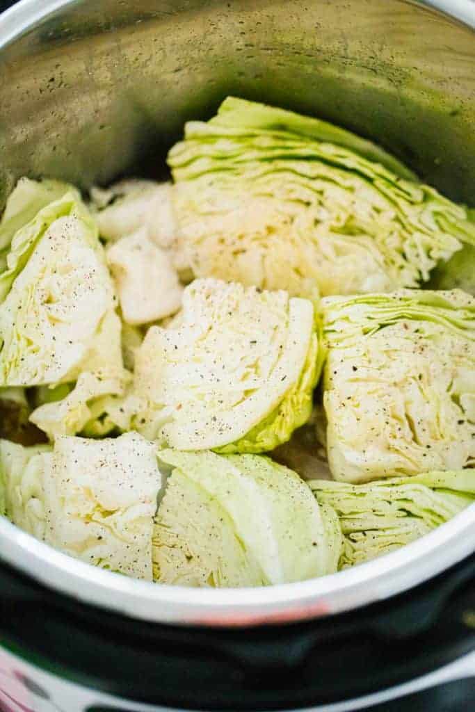 sliced and peppered cabbage pieces stacked in instant pot