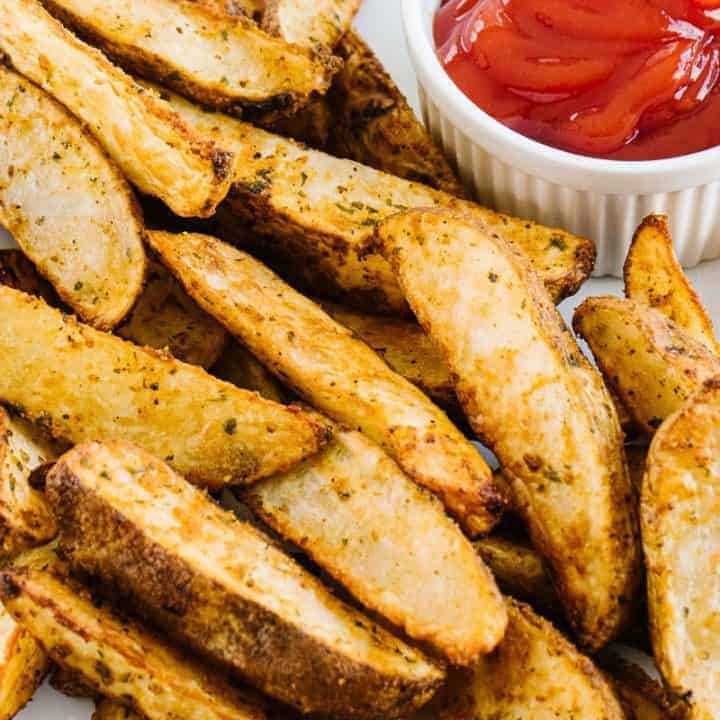 air fryer potato wedges next to a bowl of ketchup