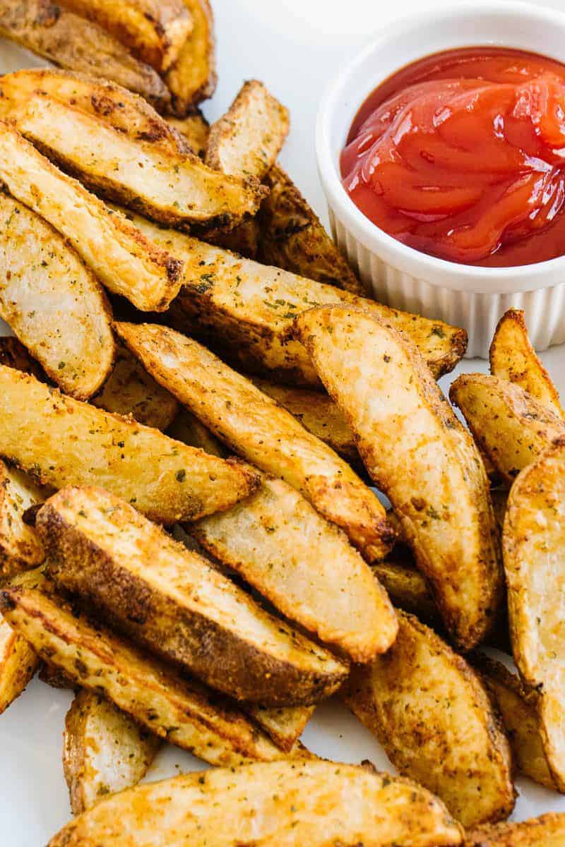air fryer potato wedges next to a bowl of ketchup
