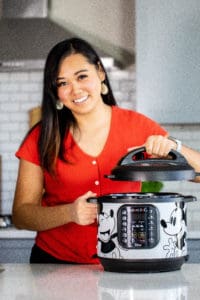 Lisa childs holding an instant pot lid with a mickey instant pot
