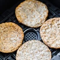 four cooked sausage patties in air fryer