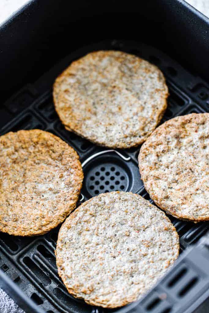 four cooked sausage patties in air fryer