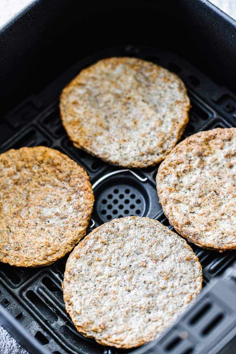 four cooked sausage patties in air fryer