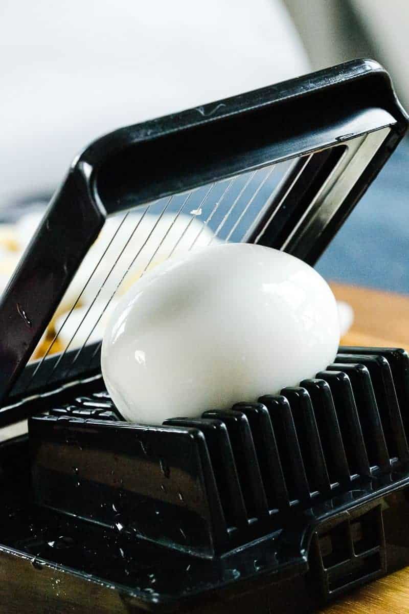 whole, shelled, presliced egg in a black egg slicer