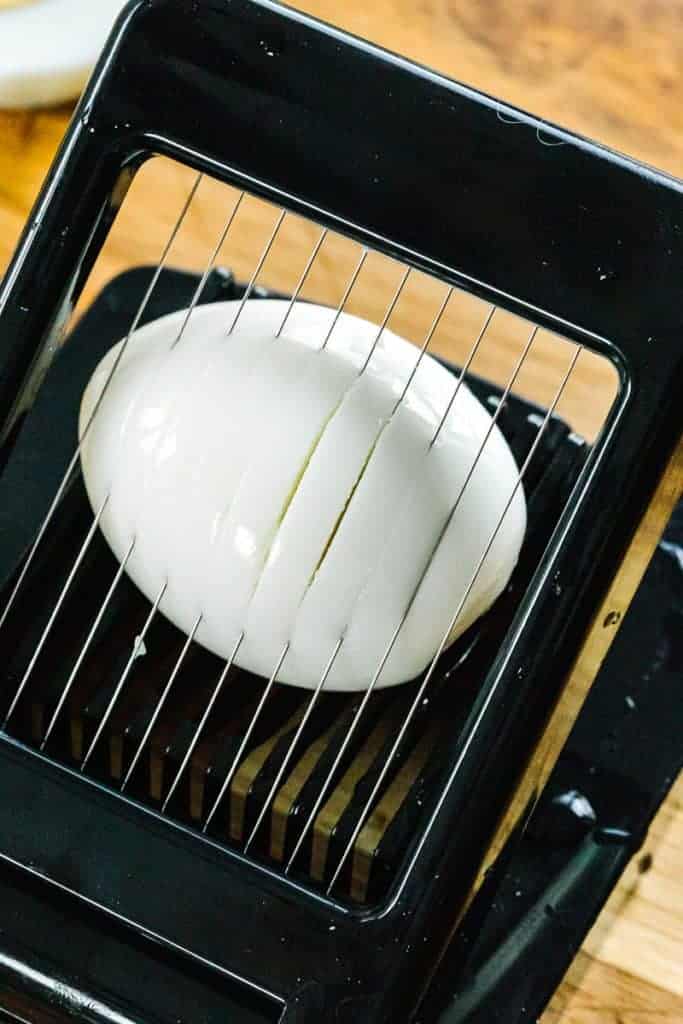 instant pot egg being sliced in black egg slicer