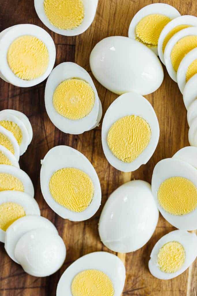 Several air fryer eggs sliced in half to show cooked yellow yolk and egg whites