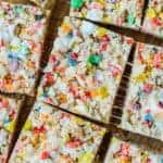 close up of fruity pebble rice krispies cut next to each other with marshmallow strings showing from being pulled