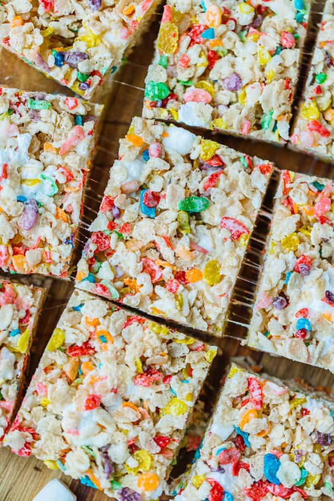 close up of fruity pebble rice krispies cut next to each other with marshmallow strings showing from being pulled