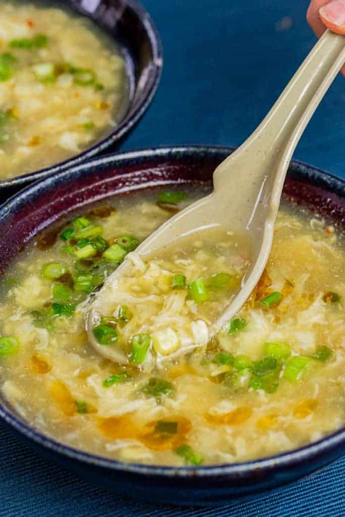 a bowl of egg drop soup with a japanese spoon on top of it