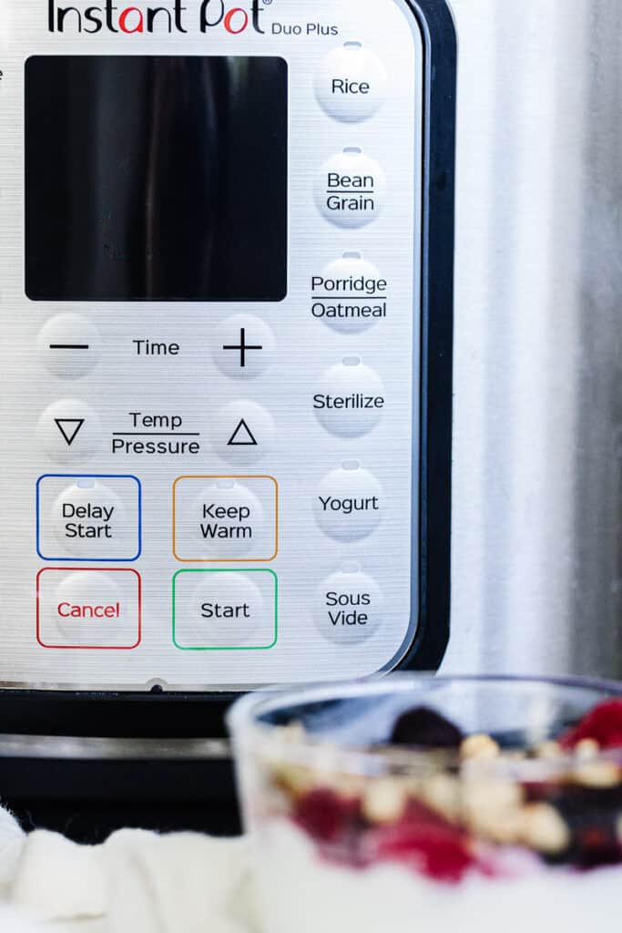 photo of instant pot buttons featuring yogurt button with cup of instant pot yogurt in front