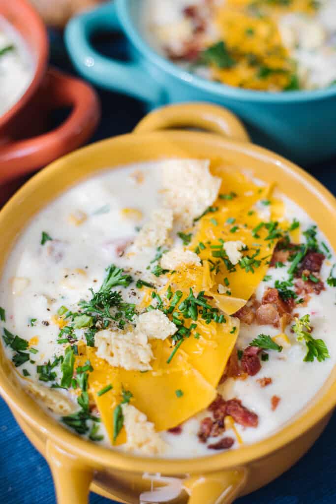 Close up of potato ham chowder in a yellow bowl
