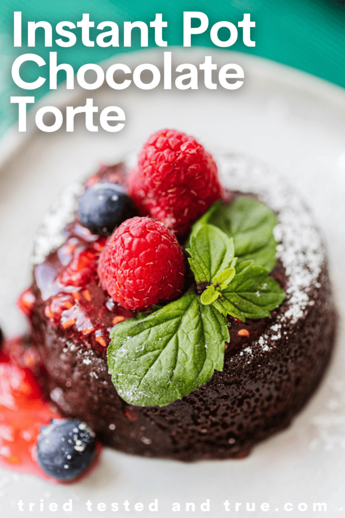 Graphic of Instant Pot Chocolate Torte with a picture of a chocolate torte topped with berries, powdered sugar, and a mint leaf.